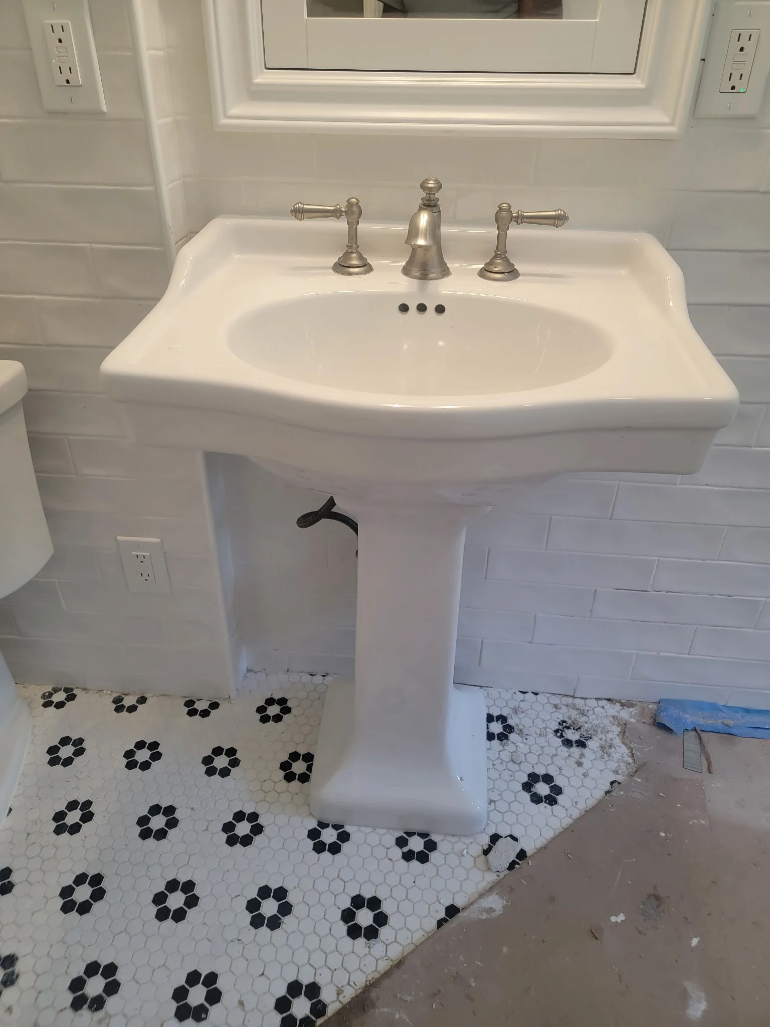 Newly installed pedestal sink with widespread bathroom faucet