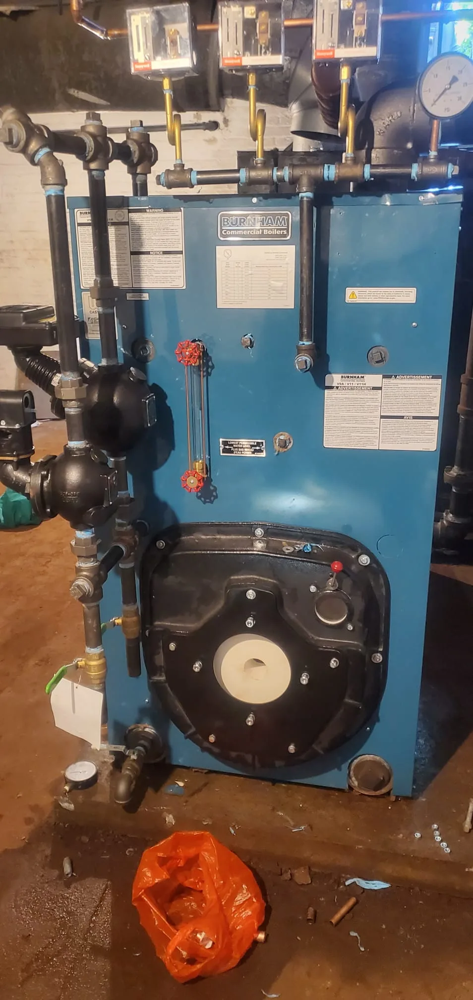 Newly installed commercial-grade boiler with copper piping and pressure gauge