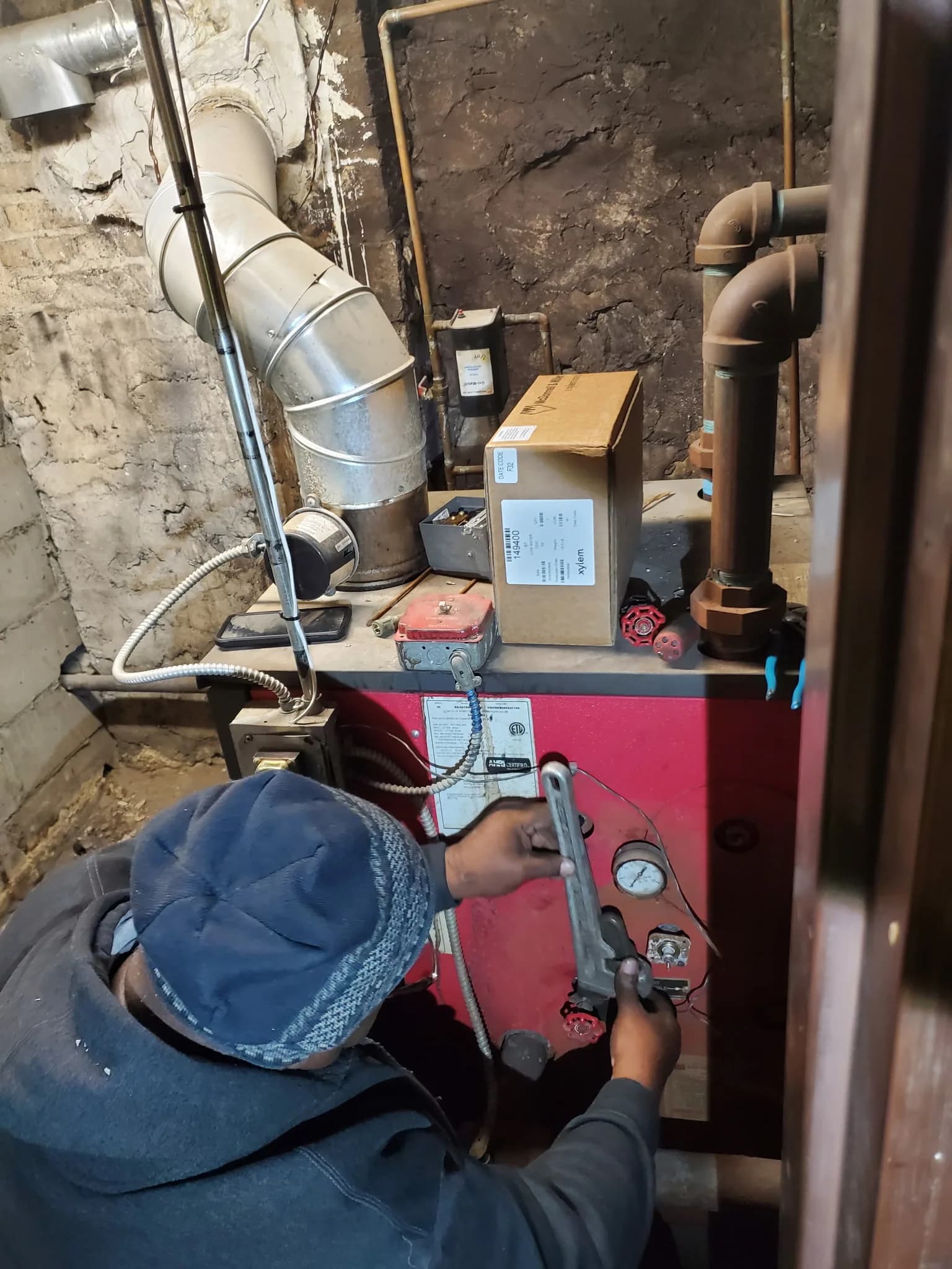 Technician using a wrench to repair a residential boiler's pressure valve