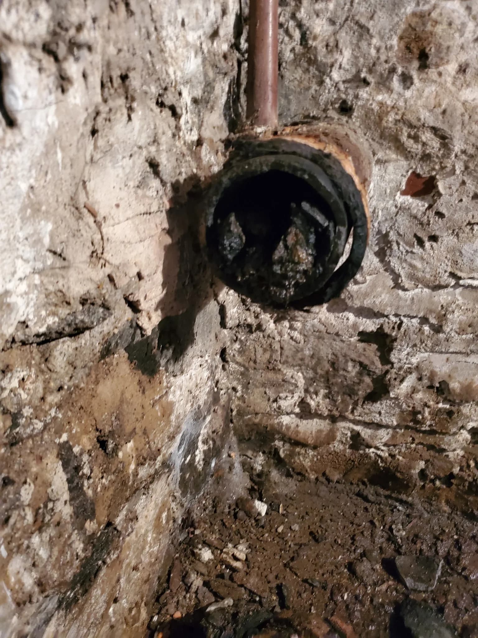 Exposed pipe cleanout fitting accessed during a drain cleaning job