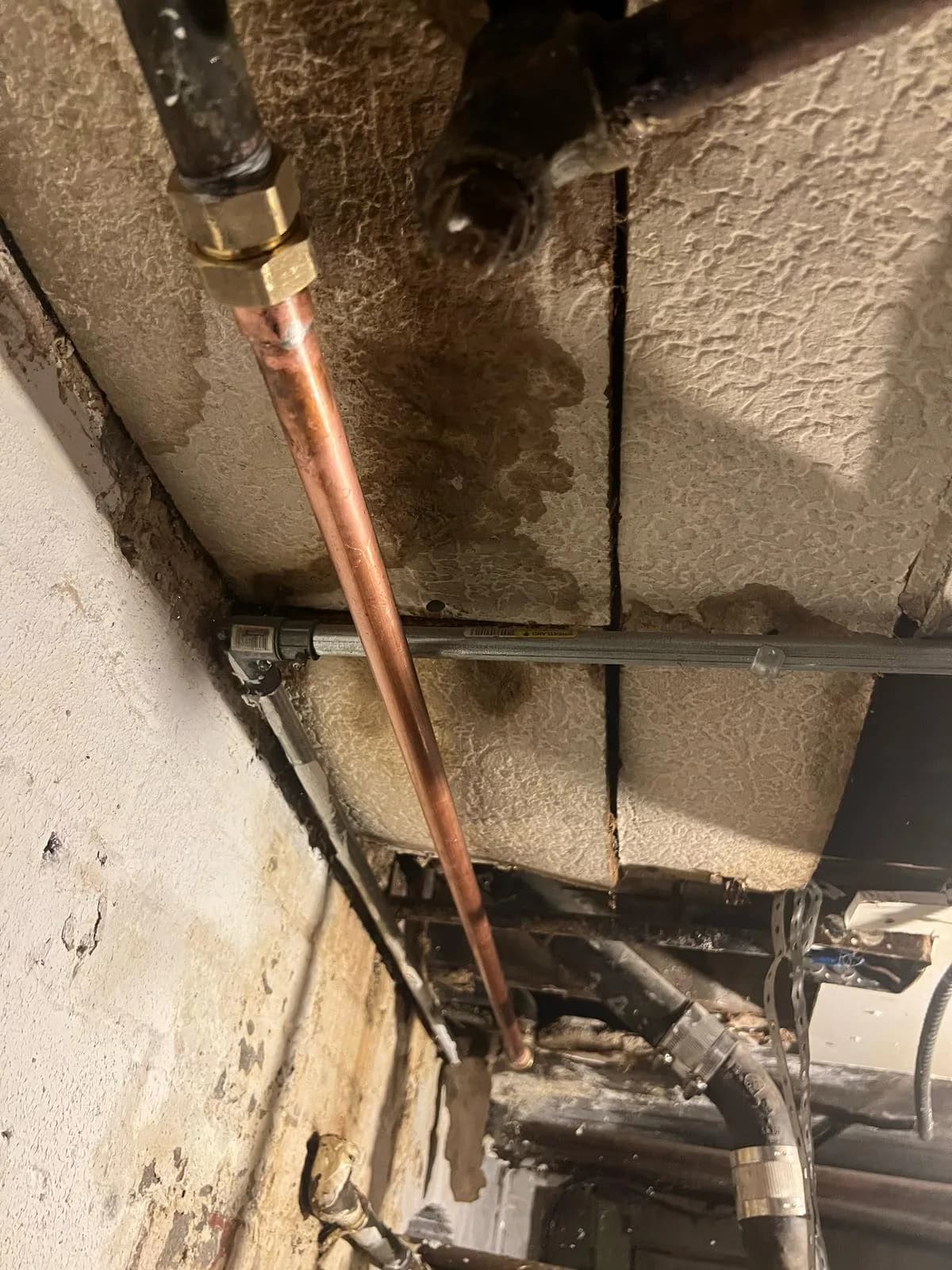 New copper supply pipe repair replacing old piping in a basement wall