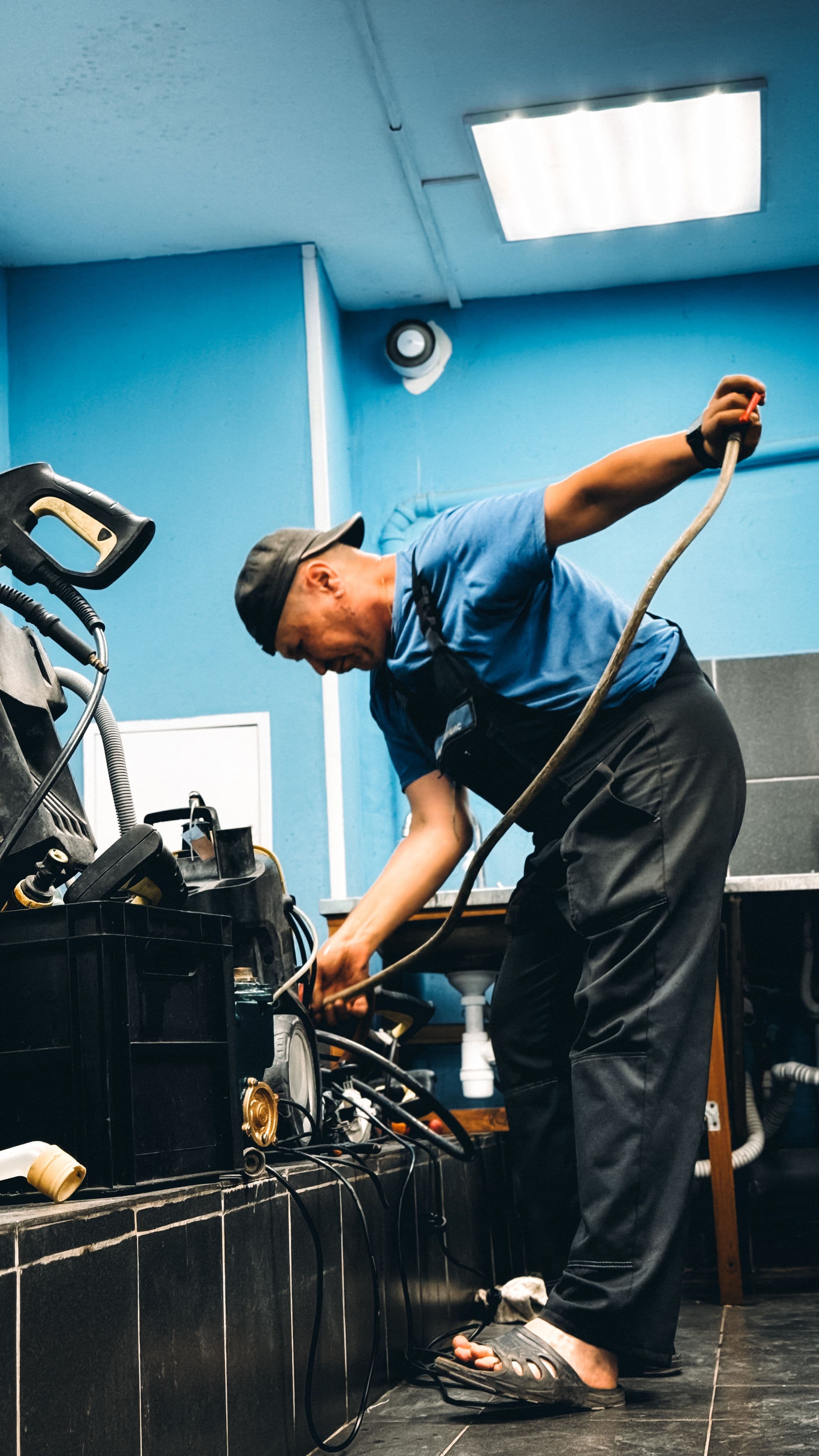 Technician connecting equipment lines during a water heater service call