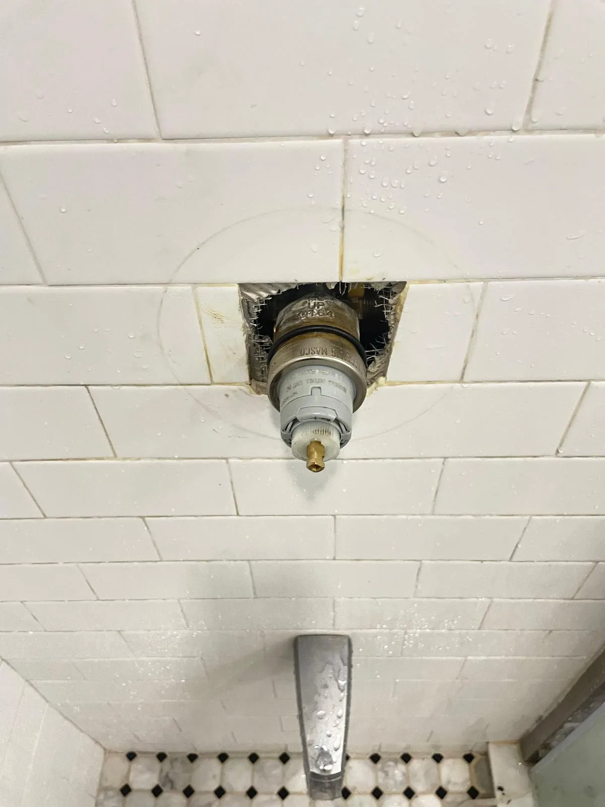 Shower cartridge valve exposed in the wall during a replacement job