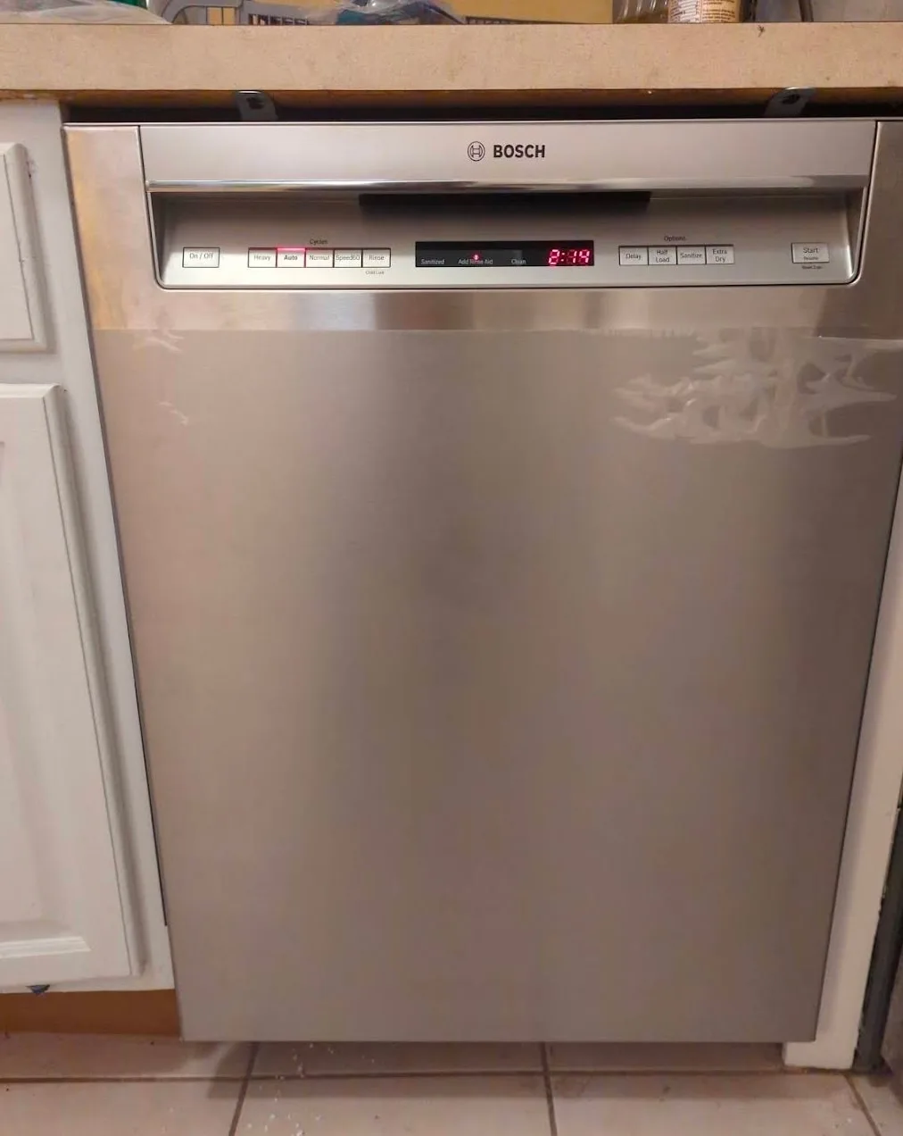Newly installed stainless steel dishwasher under a kitchen counter